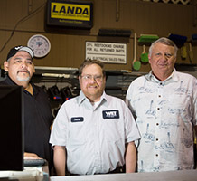 three gentlemen behind a counter