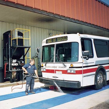 Worker washing city bus with Super Red II