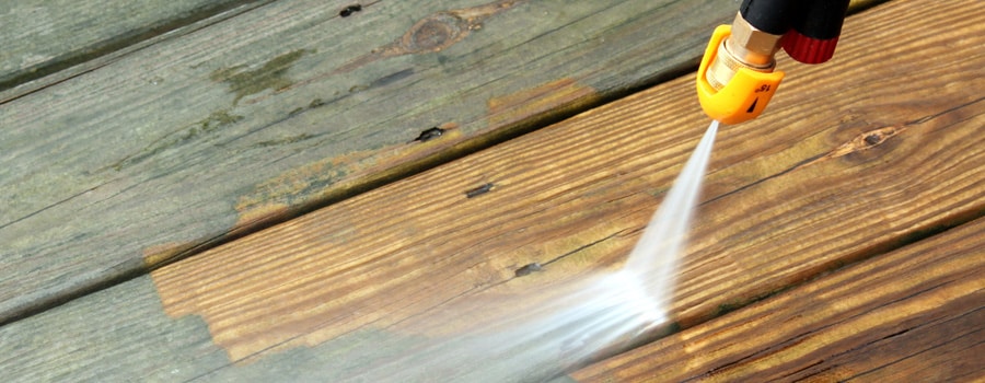 pressure washer cleaning a deck