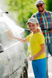 spraying pressure washer towards another person