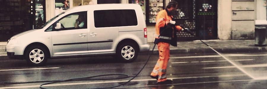 Man using a pressure washer in the street