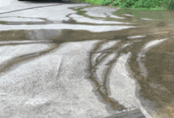 A floor scrubber is used to clean na driveway.