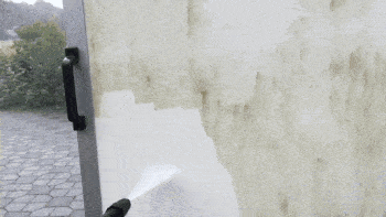 A large moving truck is cleaned with a pressure washer.