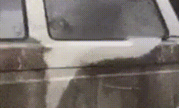 Cleaning the dirt off a truck with a power washer.