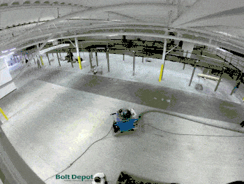 Workers at a warehouse prime then epoxy a floor.