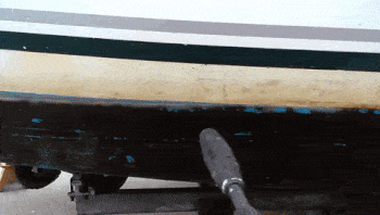 A pressure washer cleans years of algae from a boat.