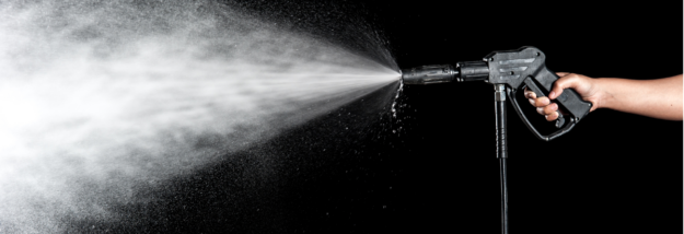 pressure wash this not that A person holding a pressure washer spraying water.