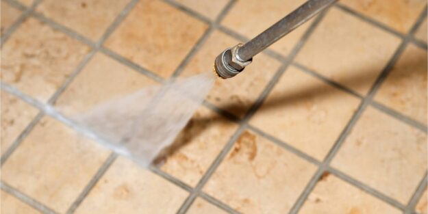 Commercial pressure washing A pressure washer spraying water on a tiled floor.