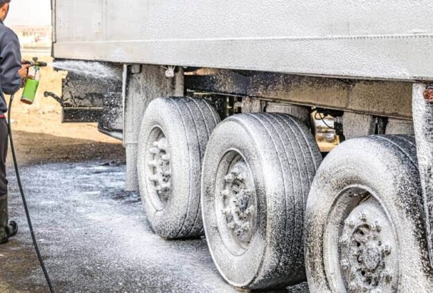 Using Detergents When Pressure Washing Pressure washing detergent sits on the wheels and the side of a large commercial vehicle as the owner starts hosing it down with a pressure washer.